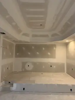 Basement hallway with arched drywall entry and bathroom rough-in walls partially sheeted in cement board — Atlanta, GA
