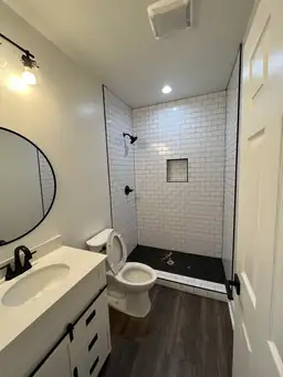 Bathroom remodel with white subway tile shower, black penny tile accent strip, and matte black fixtures — Metro Atlanta, GA