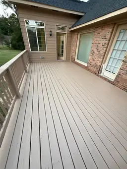 Wide tan composite deck boards and white railing on completed sunroom home addition exterior — Marietta, GA