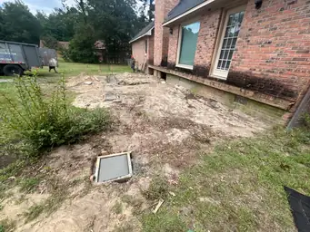 Before view of brick home side with old deteriorated deck and bare soil yard before sunroom and deck addition begins — Marietta, GA